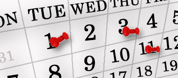 calendar paper with push pins placed on dates